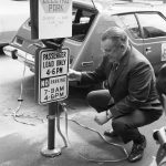 A man charges his AMC Gremlin in Seattle, Washington in 1973.