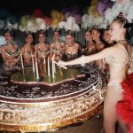 The Bluebell Girls light the candles on top of a giant cake 14 December 1971 in Paris