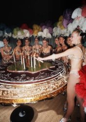 The Bluebell Girls light the candles on top of a giant cake 14 December 1971 in Paris