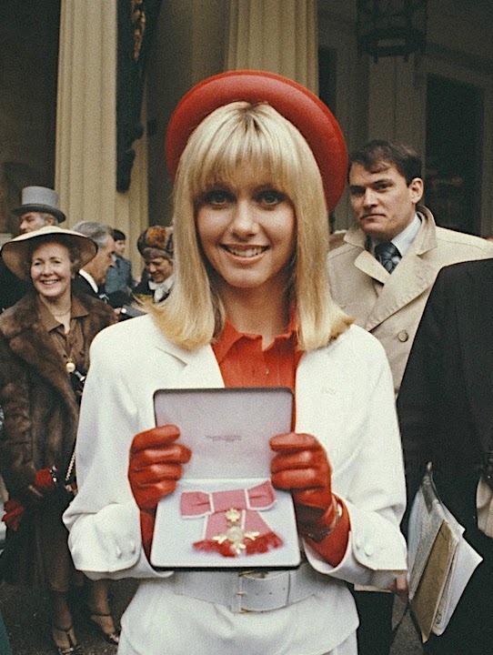 Olivia Newton-John pictured after receiving the Order of the British Empire (OBE) from Queen Elizabeth in 1979